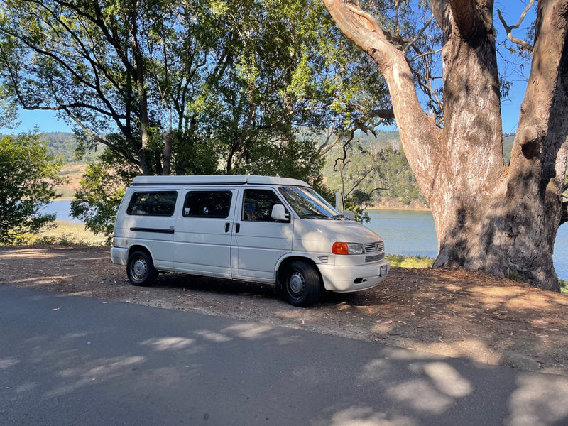  open to nature. Ideal for camping adventures.|RV rental camper van interior. Features a lower bed with blue bedding & an upper sleeping area — photo 18