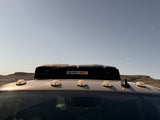 This RV rental with a ROOFNEST rooftop tent is ready for desert adventures under a clear sky.