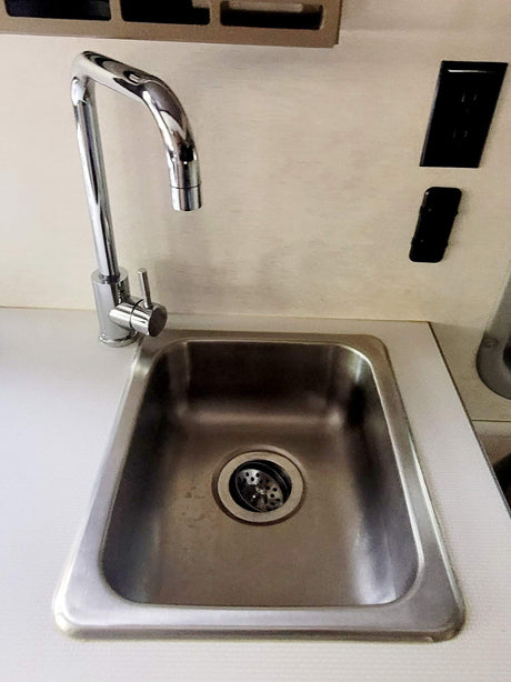 RV rental kitchen: compact stainless sink, chrome faucet, and outlets. Essential convenience on the road.