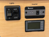 RV rental control panel: lights (on/off, dimmer), Renogy inverter (on/off, status lights), and battery monitor with display.