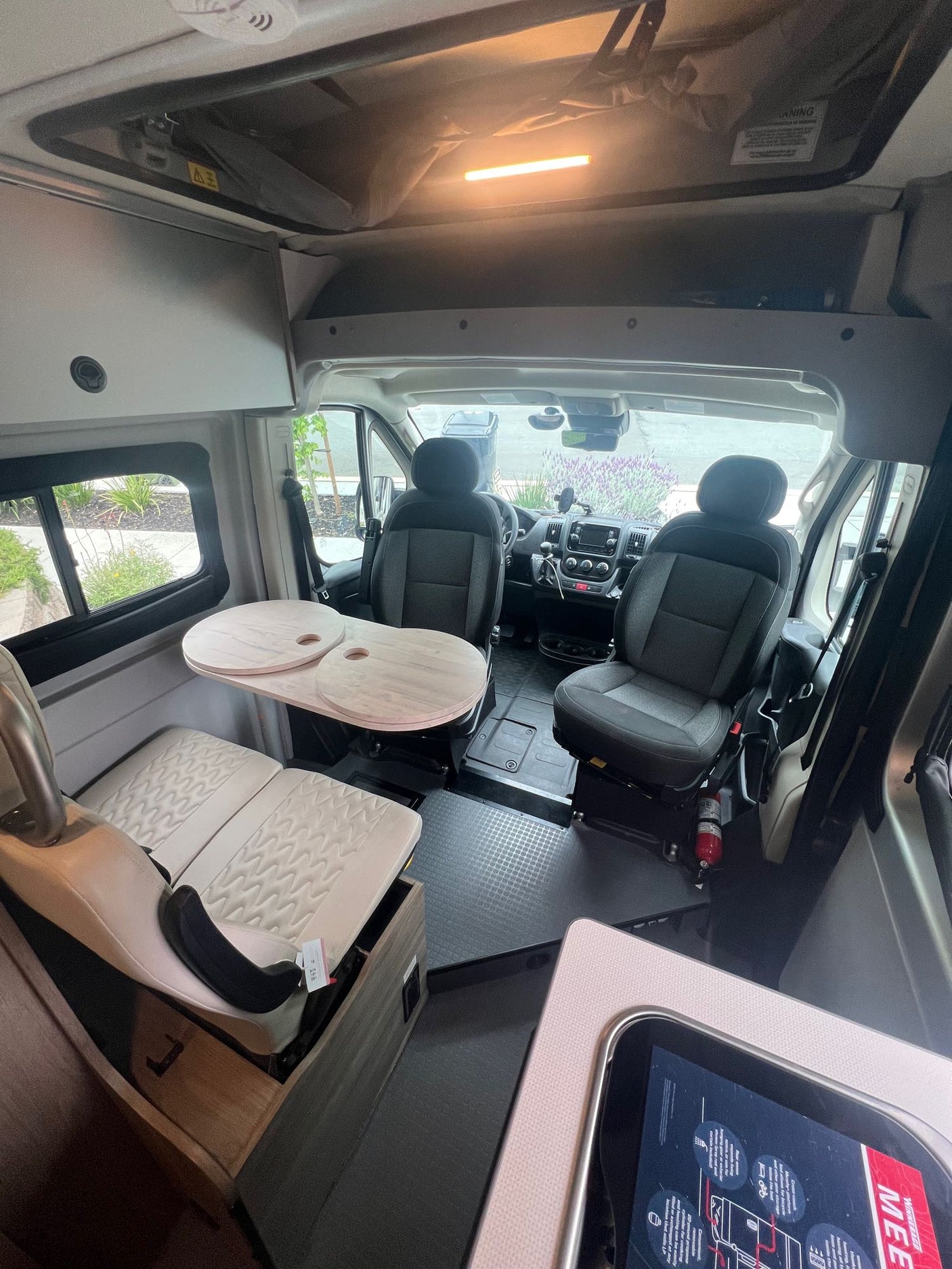 Spacious RV rental interior with a cozy dining area, swivel seats, and ample storage, perfect for travel comfort.