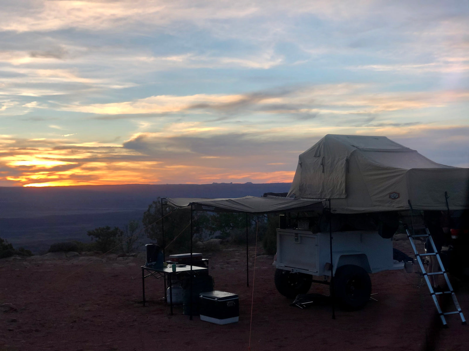 Beautiful desert sunset over a rooftop tent trailer campsite. Find your next outdoor adventure or RV rental experience!