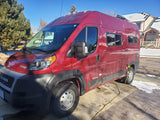 Red Ram ProMaster Winnebago RV rental, parked on a snowy driveway and plugged in.