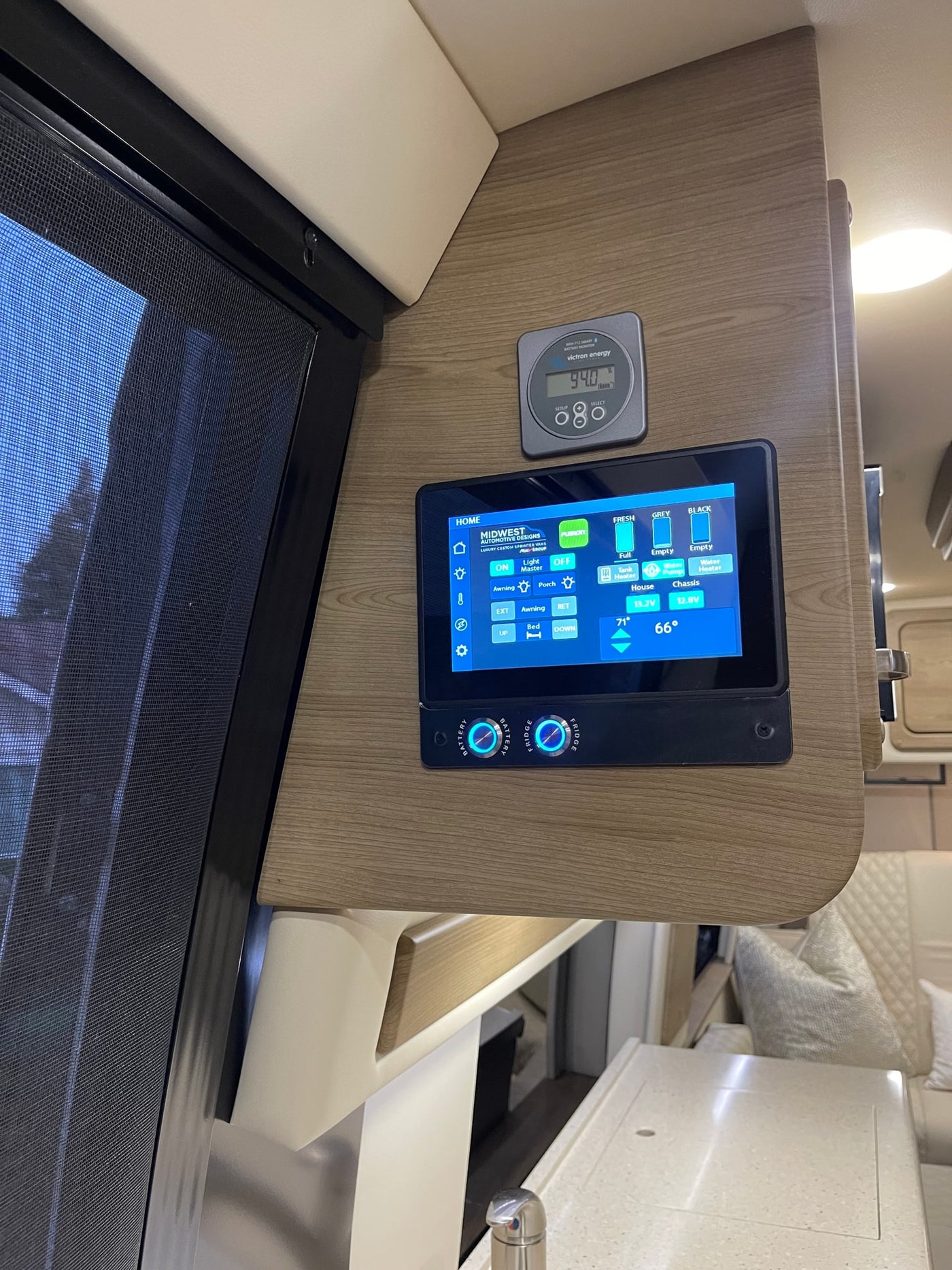 RV rental's control panel: a touchscreen shows 94% battery, water tank levels (fresh, grey, black), and controls for lights & bed. — photo 6