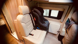 RV rental interior featuring a child safety seat securely installed in a passenger seat, ready for family travel.