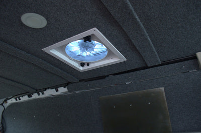 RV rental interior: Gray carpeted ceiling features a bright roof vent fan and a ceiling light, ensuring comfort on the road.