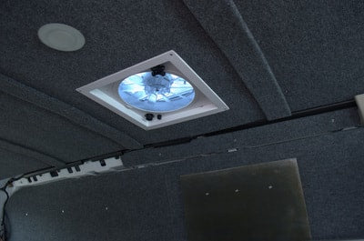 RV rental interior: Gray carpeted ceiling features a bright roof vent fan and a ceiling light, ensuring comfort on the road. — photo 11