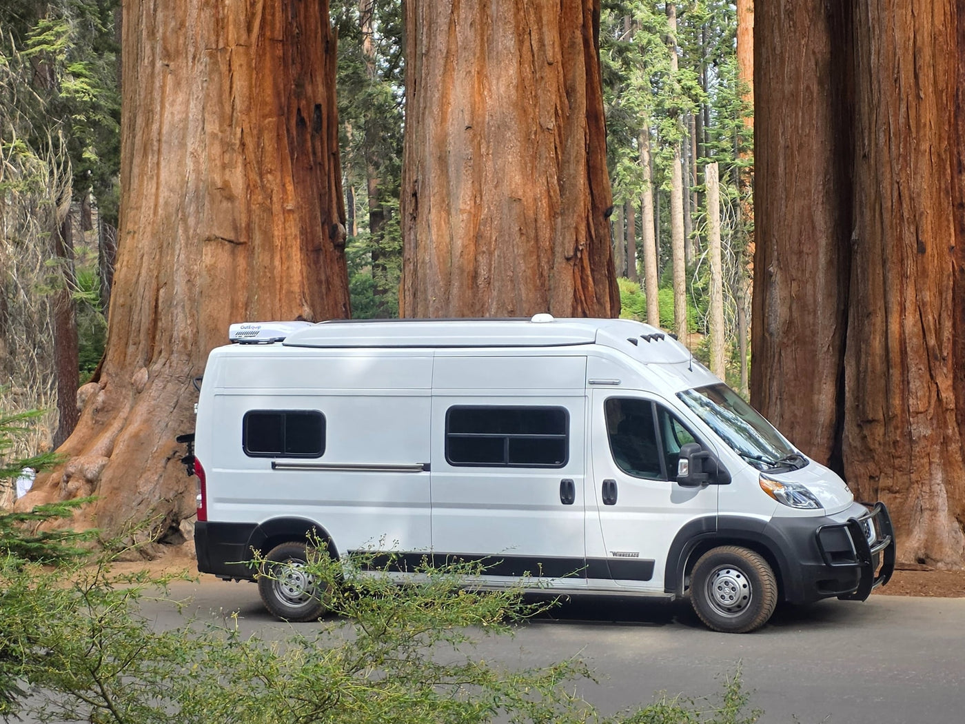 White Winnebago RV rental camper van parked on a road — photo 1