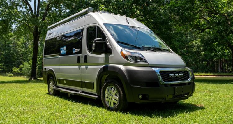 Modern silver camper van for rv rental, parked on a lush green lawn among trees. Ready for your next outdoor adventure. — photo 2