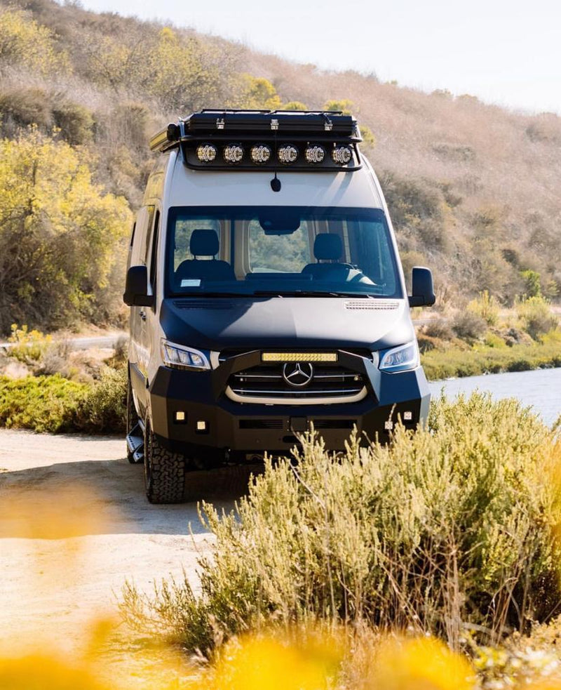  parked outdoors.|Rugged tan Mercedes Sprinter van rv rental with off-road lights and custom bumper — photo 3