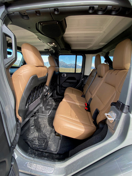 Spacious tan interior of a Jeep, with rubber mats & mountain views, perfect for an RV rental adventure.