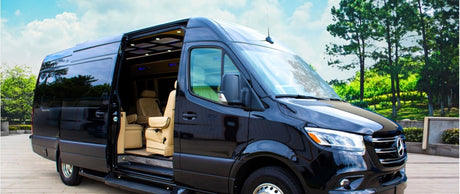 Black Mercedes-Benz Sprinter luxury van, side door open revealing light interior. Ideal for RV rental and comfortable travel.
