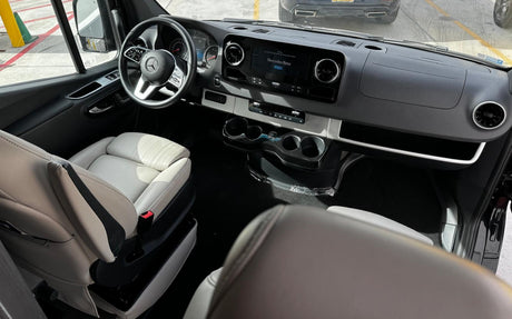 Modern Mercedes-Benz van interior for rv rental. Features plush white seats, large display, and sleek dashboard.