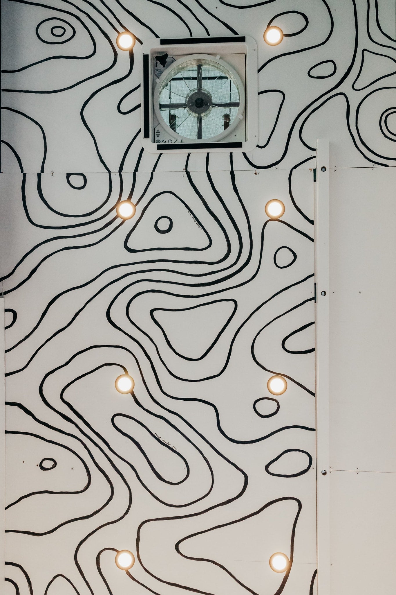 and Dometic fridge.|Custom RV rental interior featuring an adjustable wooden table — photo 12