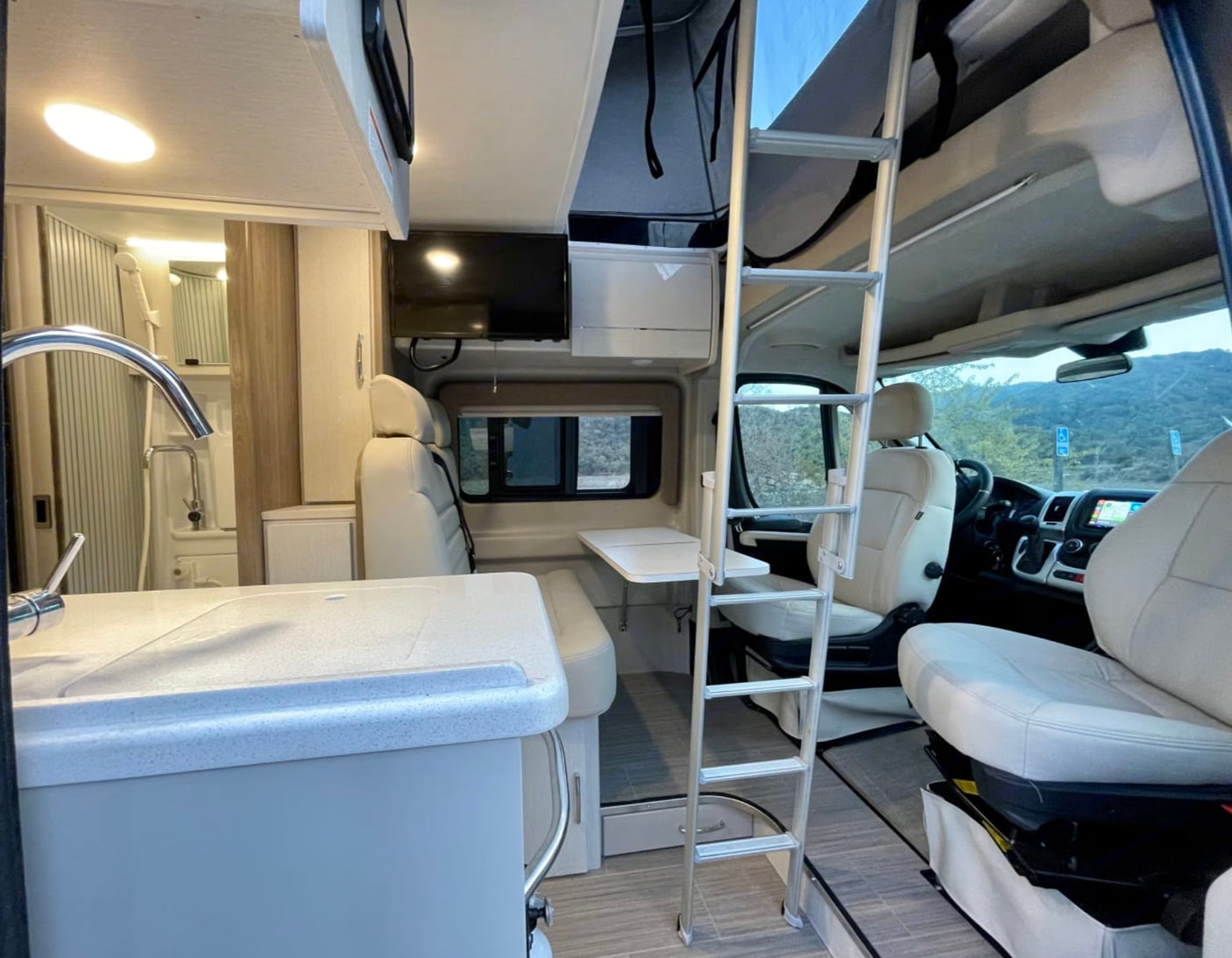  and a unique pop-top.|Modern RV rental interior: ladder to bunk