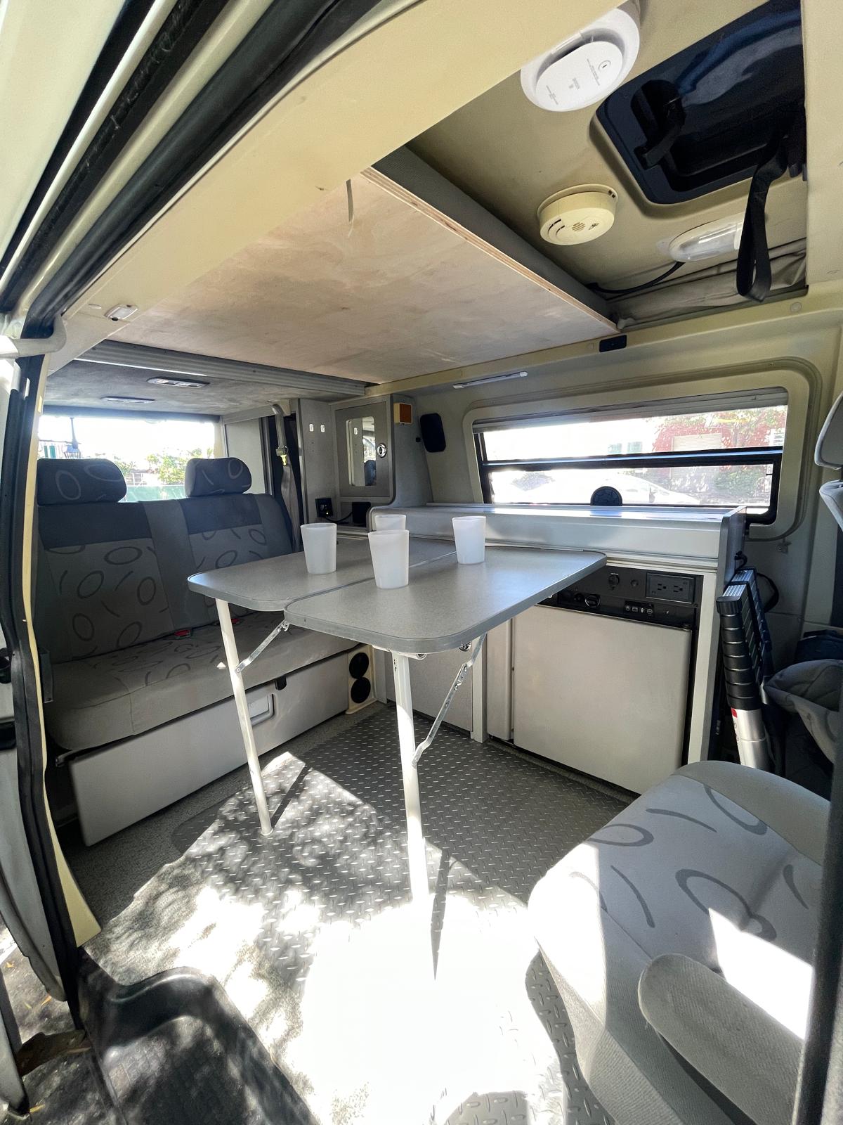  and ramen bowls.|Compact RV rental kitchen setup: stove with pan — photo 7
