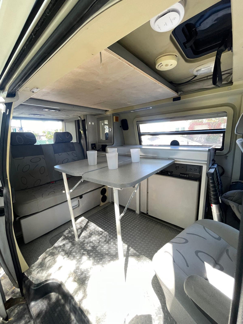 and ramen bowls.|Compact RV rental kitchen setup: stove with pan — photo 7
