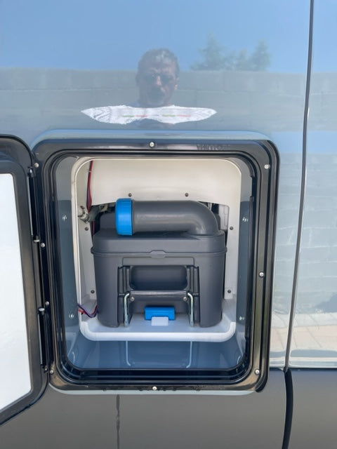 Inside an RV rental: Portable toilet waste cassette accessed via a side panel. Essential for camping trips.