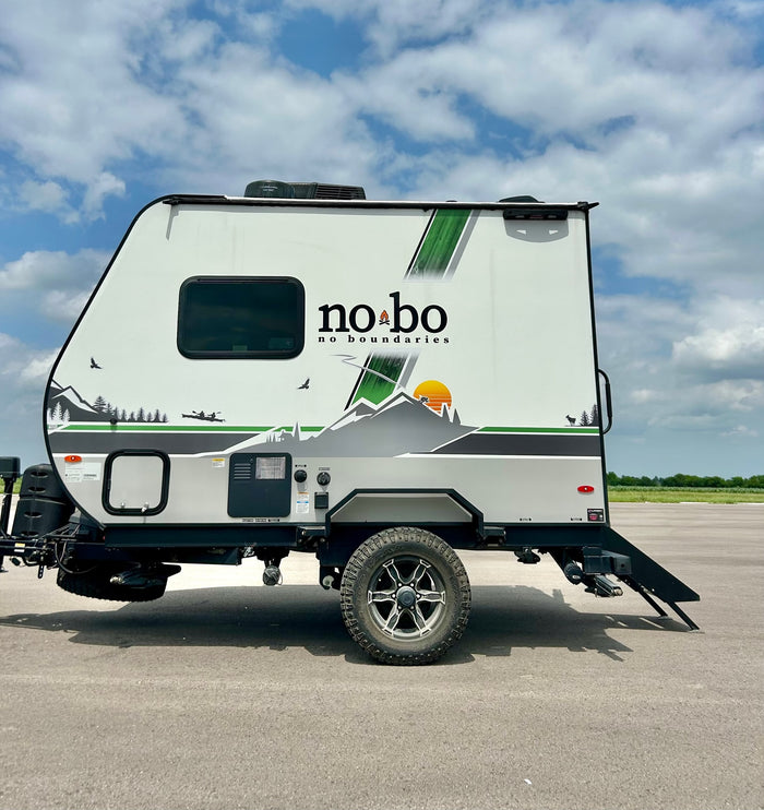 White 'no bo' travel trailer with mountain graphics, a great rv rental for your next outdoor adventure.