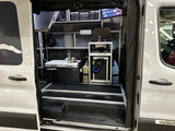 This RV rental shows a fully equipped camper van interior with a Dometic fridge, sink, and TV for mobile living.