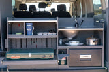 This RV rental shows a compact campervan kitchen with sink, stove, fridge, & storage, ideal for van life adventures.