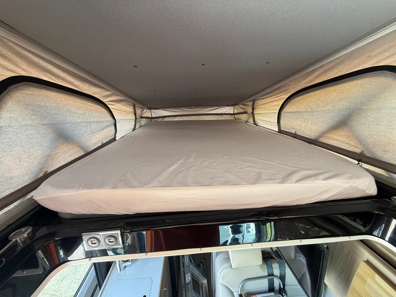 Cozy pop-top bed in an RV rental, showing the sleeping area and interior details like USB charging ports. — photo 14
