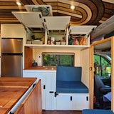 RV rental interior: cozy camper van with kitchenette, seating, and custom wood ceiling.