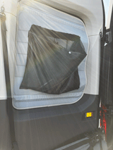 Inside a cozy rv rental: view of a padded window cover with a practical mesh storage pocket, enhancing camper comfort.