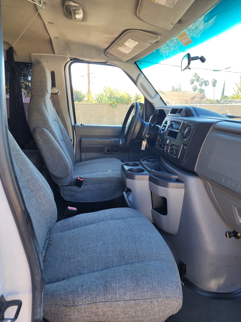 RV rental van's clean front cabin, showcasing grey seats, a functional dashboard, and steering wheel. — photo 10