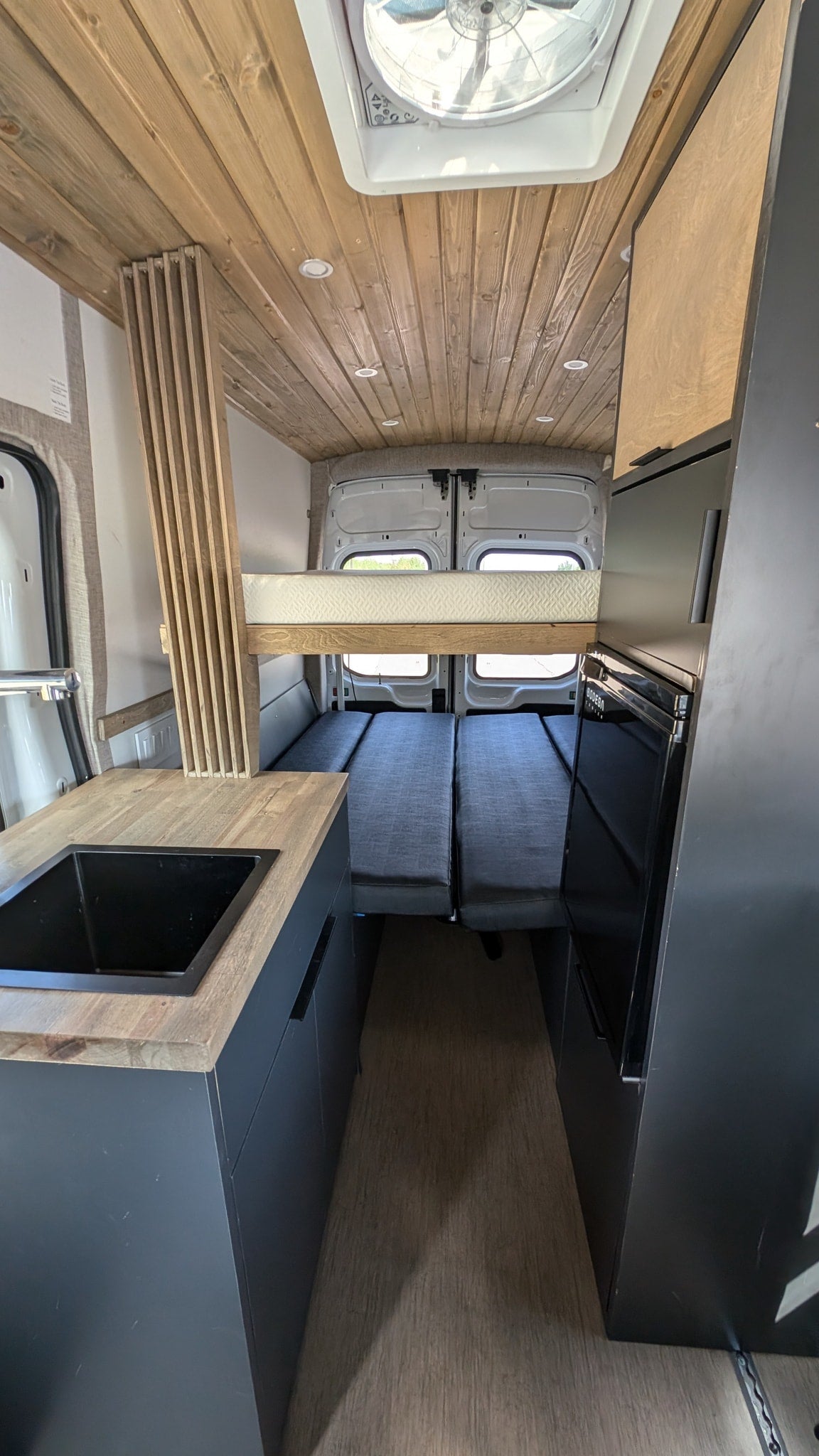  parked on asphalt with natural backdrop.|Experience this rv rental campervan interior: kitchen with sink — photo 4