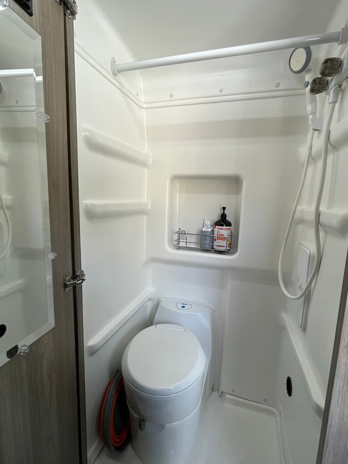 RV rental: Compact wet bath with a toilet, shower, soap caddy, and collapsible buckets. — photo 10