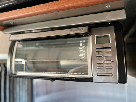 Compact Black+Decker Spacemaker toaster oven, under-cabinet mounted, ideal for an RV rental kitchen.