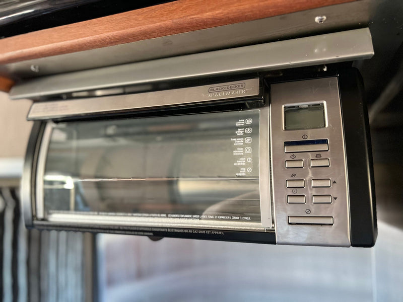  and wooden cabinets. Ready for your road trip adventures.|Explore this RV rental's compact kitchen area: microwave — photo 7