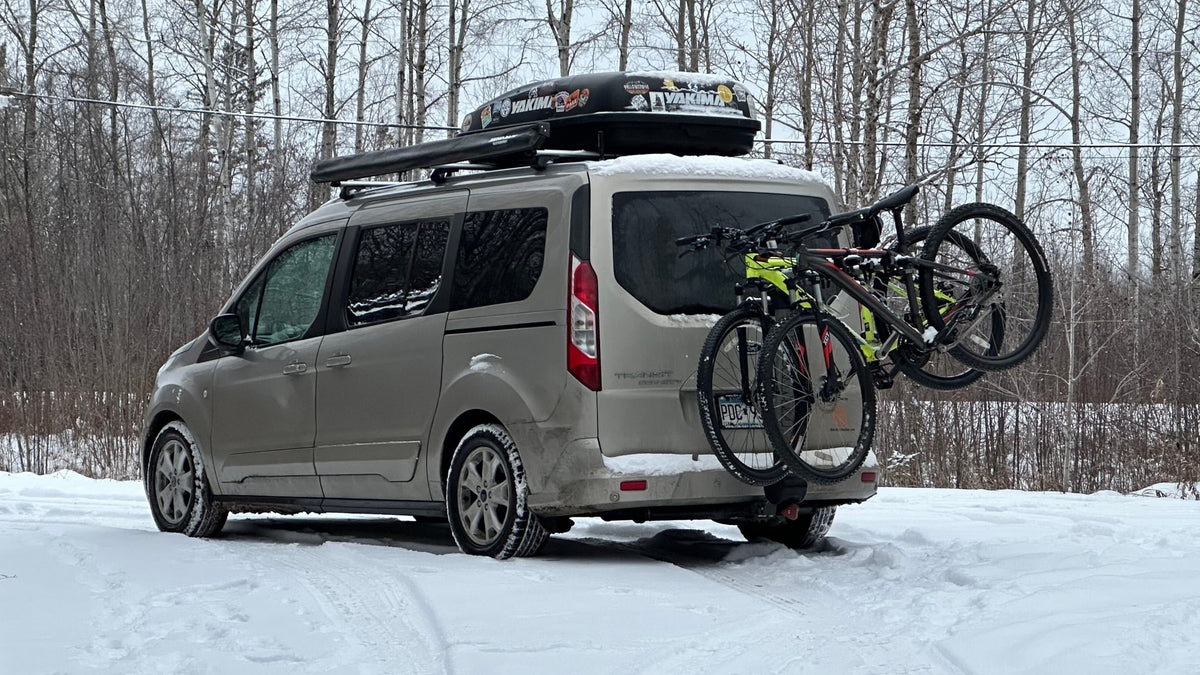 Adventure van in snow: a Ford Transit Connect with bikes, roof box, and an awning. Great for an rv rental trip. — photo 3