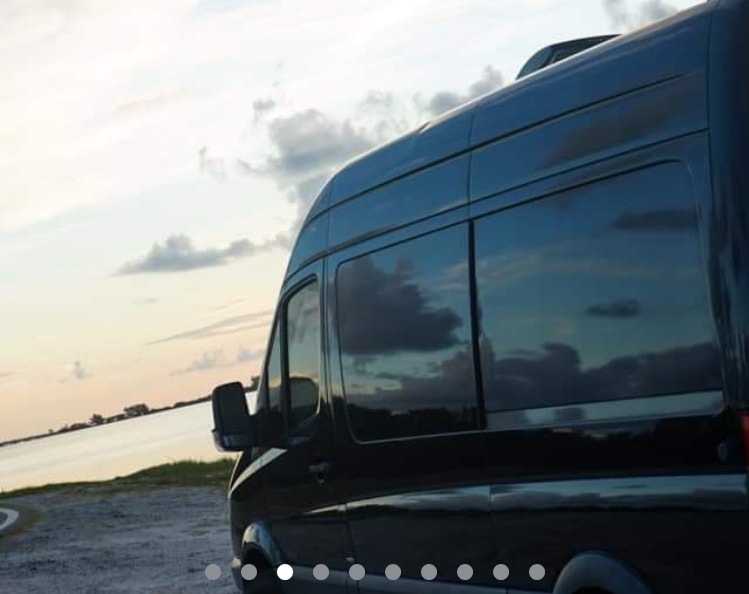 perfect for your next RV rental adventure.|Scenic RV rental: Dark van by serene water at sunset — photo 2