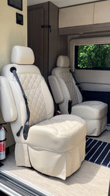 Luxury RV rental interior showcasing plush, quilted cream captain's chairs for comfortable road trips.