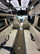 Explore this opulent rv rental interior: cream quilted leather seating, sleek black trim, ambient lighting, and spacious comfort.