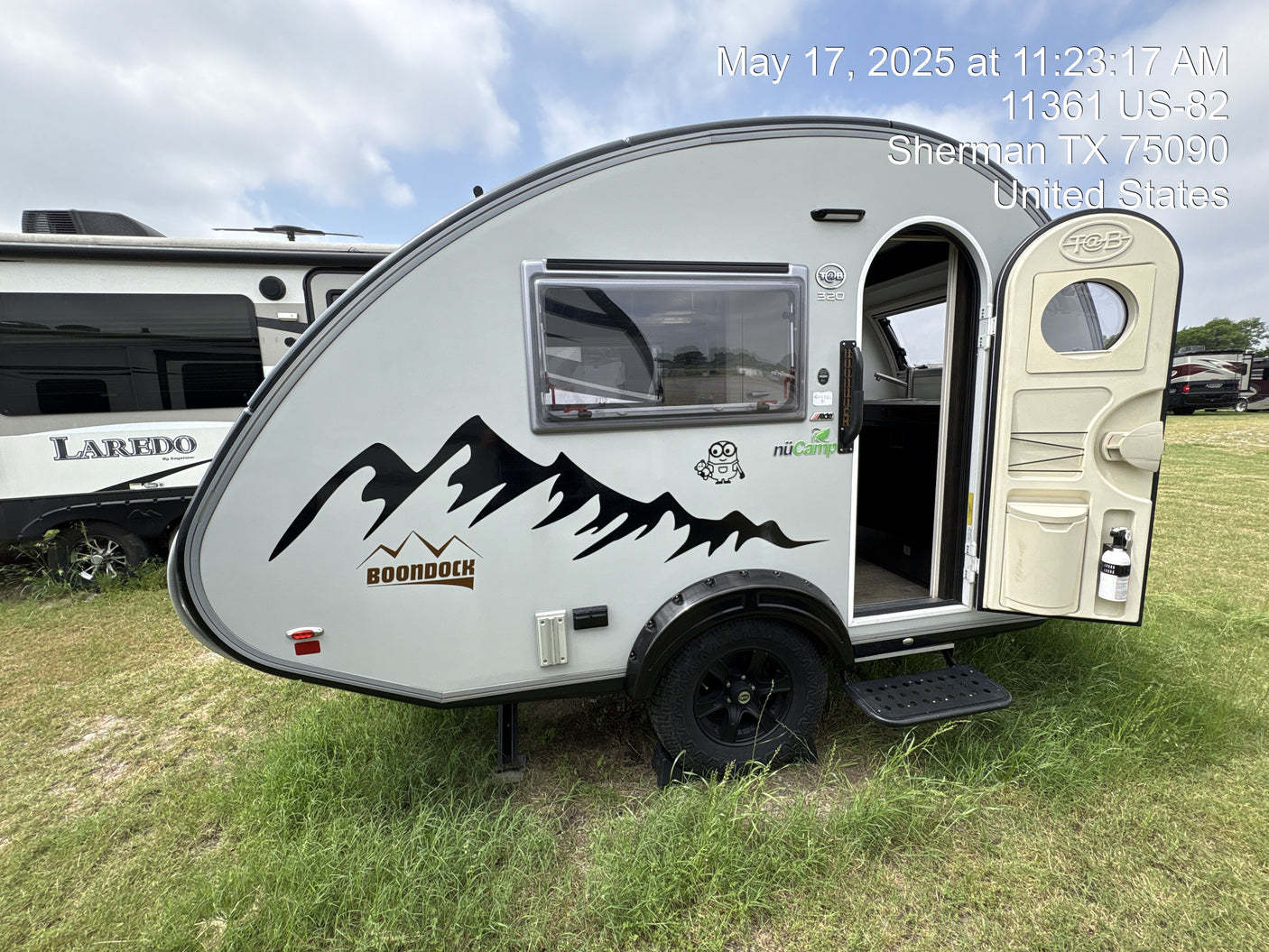 Explore this compact nüCamp Boondock teardrop camper (RV rental) parked on grass, with another RV in the background.