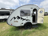 Explore this compact nüCamp Boondock teardrop camper (RV rental) parked on grass, with another RV in the background.