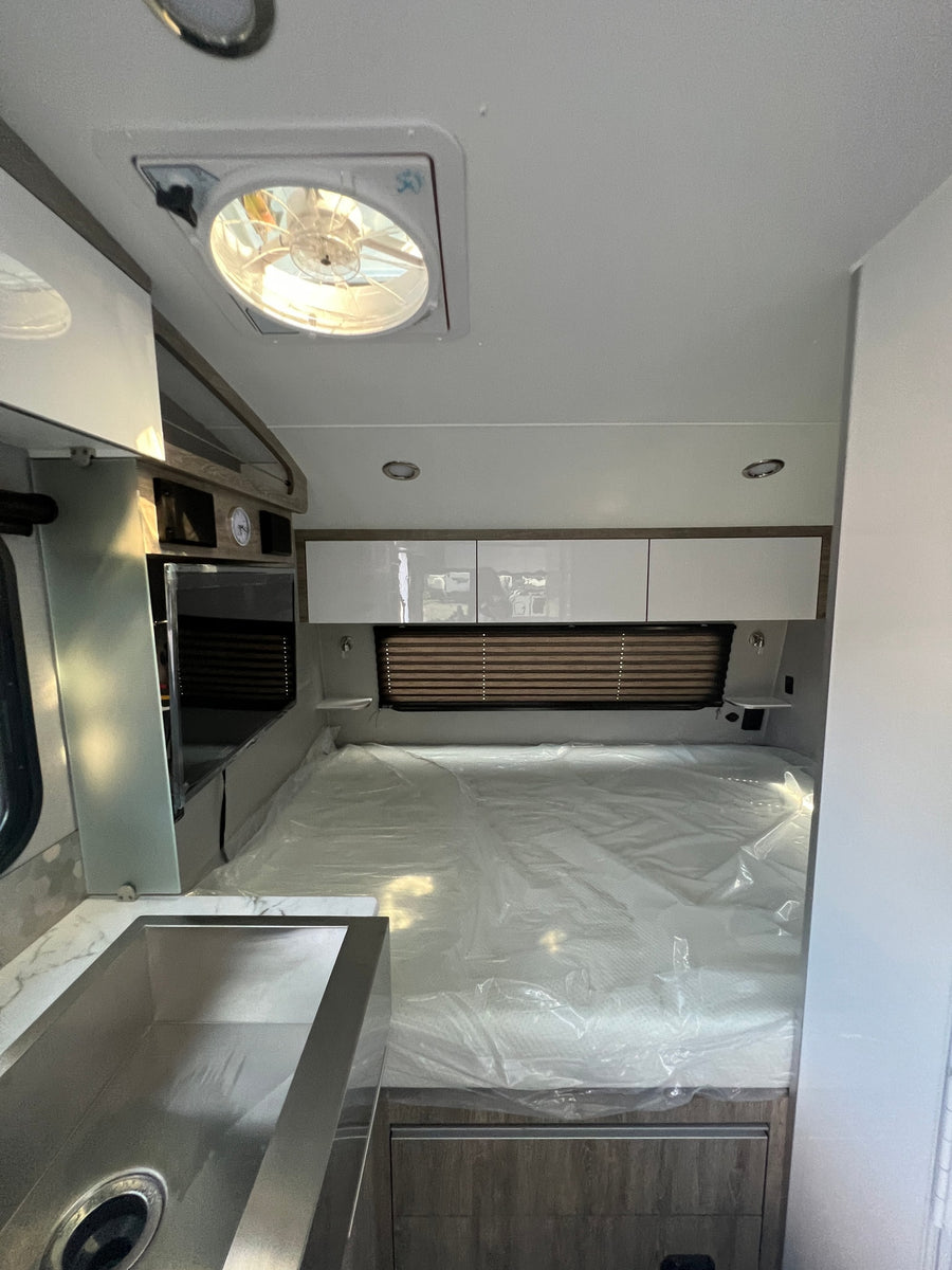  parked on a sunny outdoor lot.|Open travel trailer RV rental door showing a bright interior with a dinette