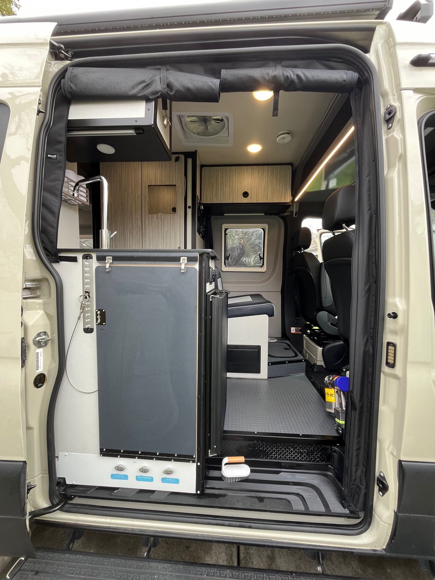  parked outdoors under trees.|White RV rental parked on a sunny mountain road with extended awning. Pine trees & rocks surround this camper van adventure.|RV rental floor plan showing a compact interior with power lift bed — photo 7