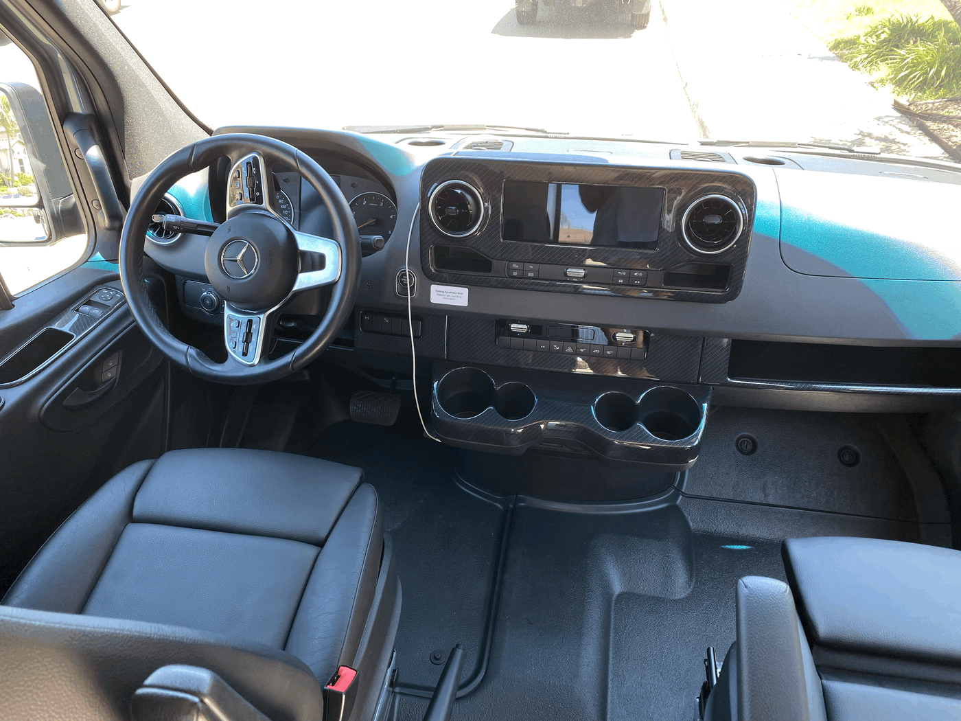 RV rental interior: Driver's view of a modern Mercedes dashboard, steering wheel, infotainment screen, and practical cup holders. — photo 8