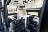 Spacious camper van RV rental interior with modern kitchenette, comfy seating, and bunk beds for adventurers.