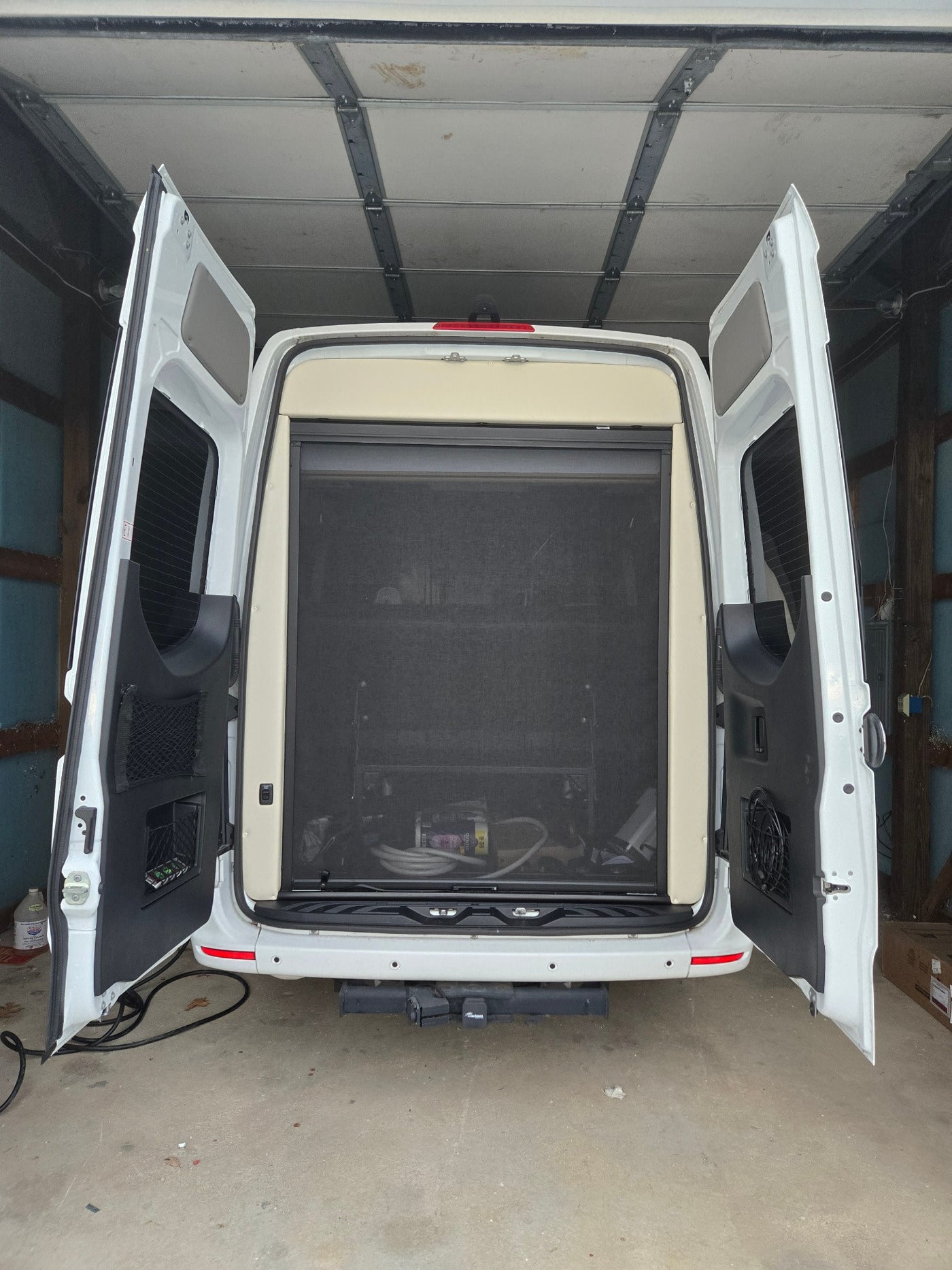  part of a modern kitchen in this comfortable RV rental.|RV rental kitchen featuring a stainless steel microwave oven above an open wooden cabinet — photo 14