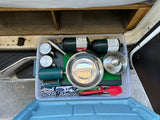 Organized RV rental kitchen bin: propane, stainless pots & mugs, plus cooking utensils for your camping adventure.