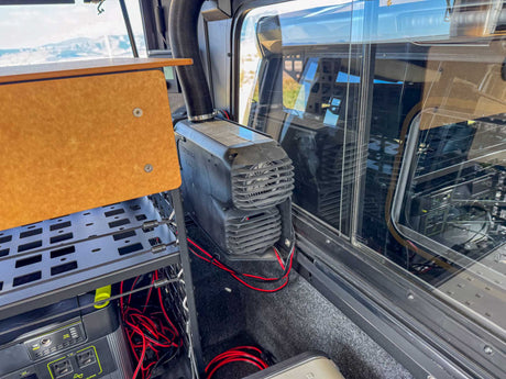  ideal for an RV rental. Parked in a mountain landscape under a blue sky.|An RV rental's comfy bed overlooks a scenic mountain range and grassy field through a screened window. Perfect camp view!|Customized Toyota Tacoma TRD Pro with an overland rooftop tent and awning