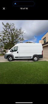 White cargo van, often used for rv rental or deliveries, parked on a driveway next to artificial grass.