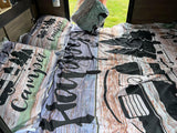 Rustic wood grain & camper-themed bedding in an RV rental. Perfect for your next camping adventure!