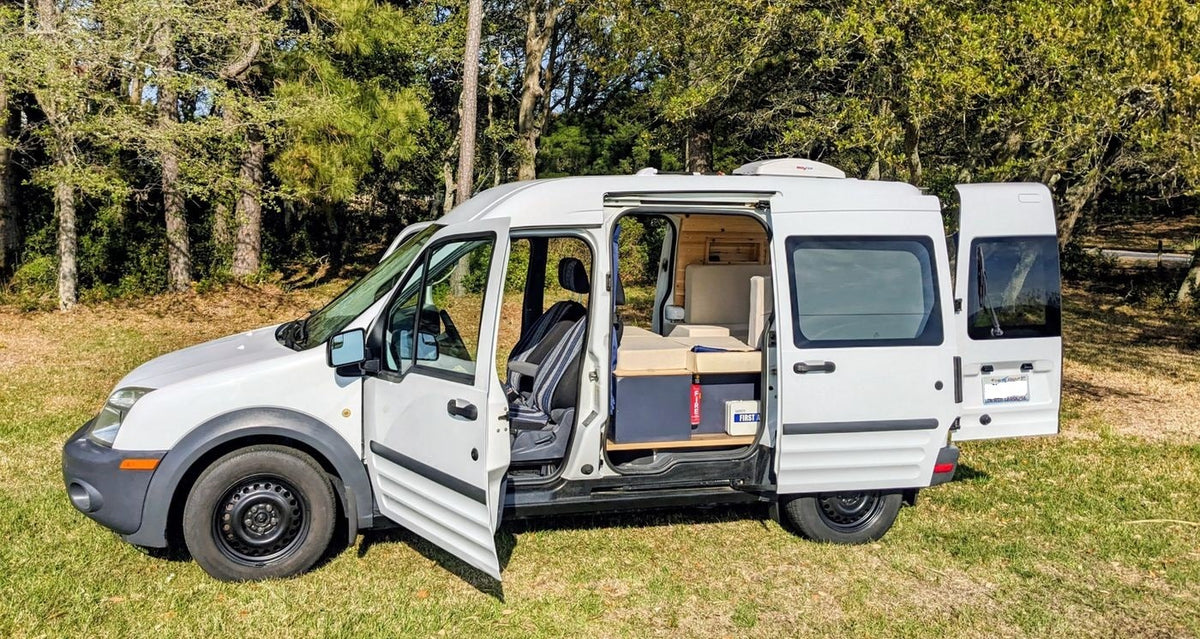 perfect RV rental for waterside adventures. Parked on grass with a scenic water view.|White camper van — photo 5
