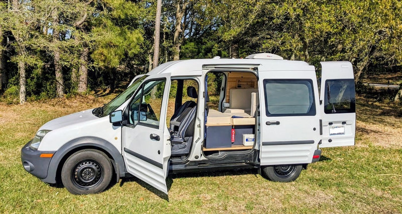  perfect RV rental for waterside adventures. Parked on grass with a scenic water view.|White camper van — photo 5